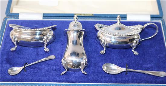 A cased silver three piece condiment set and five other items.